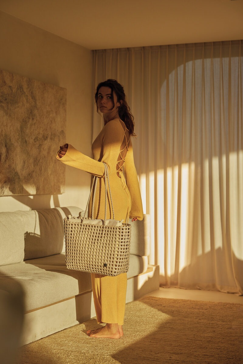 Frau in einem Wohnzimmer in einem gelben Kleid mit dem MAZE Shopper in pearl white